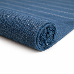 Tapis de yoga en coton biologique bleu roulé, montrant la texture dense du tissage artisanal et les finitions naturelles, idéal pour le transport et le rangement.